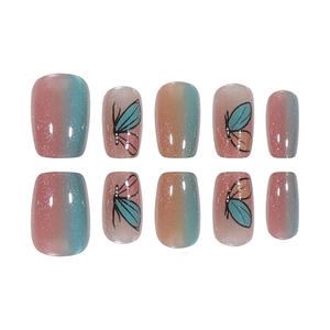 Pink and teal gradient press-on nails with butterfly wing patterns and cat-eye glitter