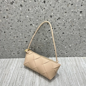 Detail view of beige woven leather handbag featuring gold zipper and premium texture