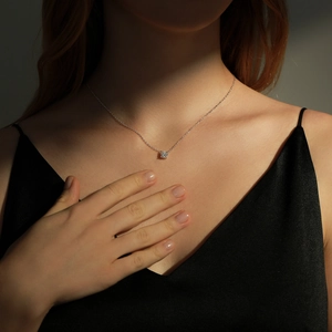 Elegant 925 sterling silver necklace with a brilliant round moissanite pendant on a model