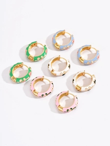 Close-up of vintage enamel flower hoop earrings in four colors with gold plating