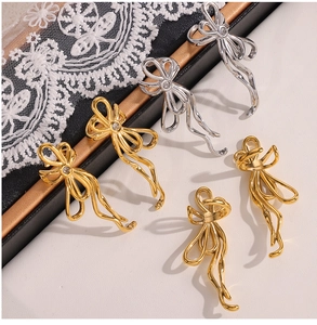 Close-up of geometric U-shaped bow earrings with sparkling cubic zirconia in gold and silver