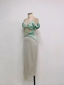 Détail d'une robe bicolore avec haut en satin vert et jupe beige avec découpe à la taille