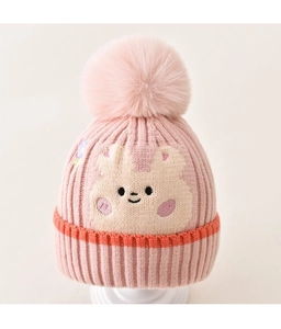 Detail of pink knitted baby hat featuring a fluffy pom-pom and cute bear face embroidery