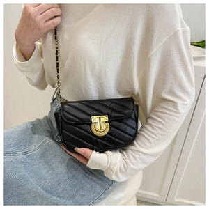 Detail of black crossbody bag featuring V-quilted texture and gold chain strap