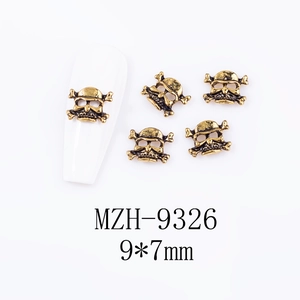 Macro shot of vintage gold skull and crossbones nail art stud, 9x7mm size detail