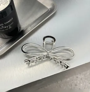 Close-up of a silver metal bow hair claw clip with a sleek polished finish