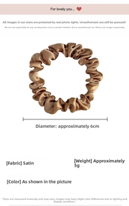 Detailed view of a small bronze satin scrunchie with 6cm diameter and silk-like texture