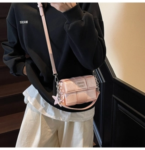 Sac bandoulière tissé rose avec pendentif étoile porté par un mannequin