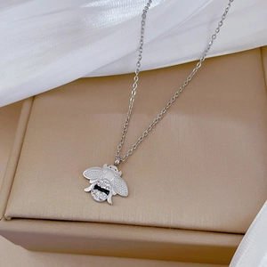 Détail du pendentif abeille argentée avec cristaux sur une boîte cadeau de bijoux