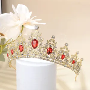 Macro shot of luxury gold tiara with red teardrop gems and white crystals on a pedestal