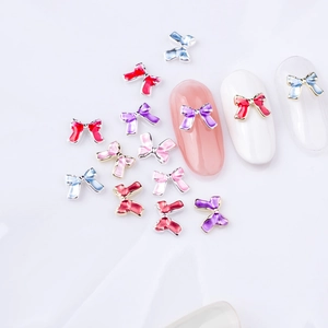 Détail macro de nœuds métalliques colorés pour nail art aux finitions émaillées
