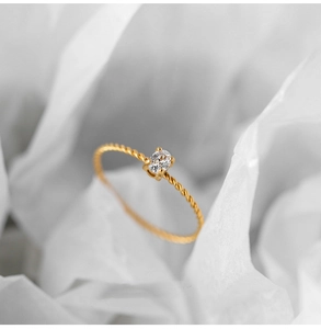 Macro detail of oval zircon stone set on a twisted 18K gold-plated titanium steel ring