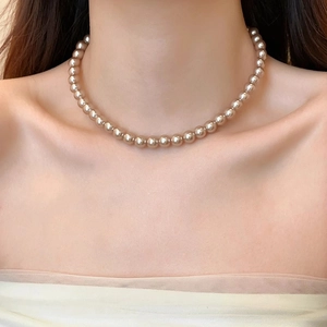 Elegant champagne gold pearl necklace for women featuring high luster beads on a model