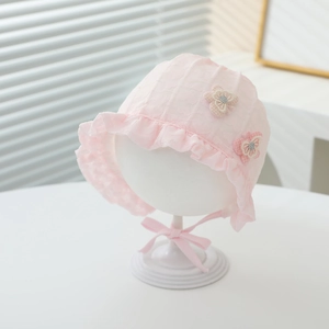 Detail of pink lace baby sun hat with floral ornaments and ruffled lace edges