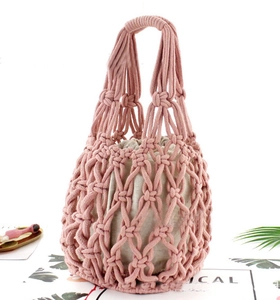 Detail of pink cotton rope macrame bag featuring diamond weave and white drawstring pouch