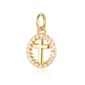Macro shot of gold-plated circular pendant with a zircon-encrusted cross and clear stones