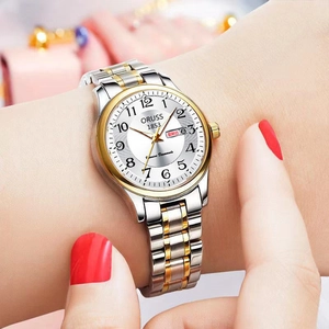 Détail d'une montre à quartz bicolore en acier inoxydable avec guichet jour-date blanc
