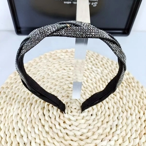 Detail shot of braided headband with sparkling dark grey rhinestones on a display stand