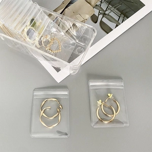 Clear PVC jewelry pouches and transparent storage box for organizing golden earrings