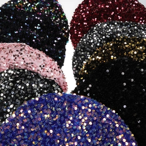 Close-up of velvet sequin berets in various colors showing rich textures and sparkle