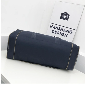 Detail of blue cylindrical travel duffel bag with reinforced handles and khaki trim
