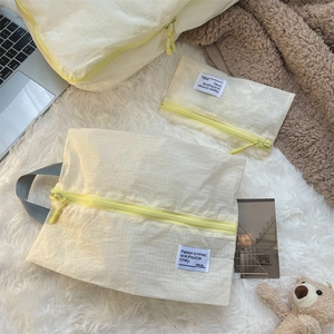 Detailed set of three light yellow checkered waterproof nylon travel storage bags