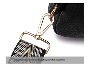 Detail of gold metal detachable hook and colorful woven shoulder strap on black bag