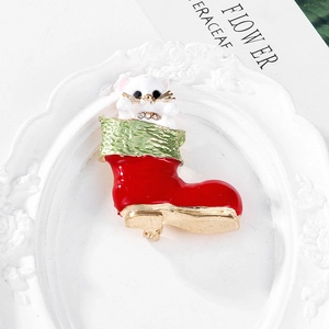 Detail of cute white cat in red Christmas stocking brooch on vintage book background
