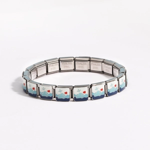 Detail of stainless steel stretch bracelet featuring blue and white ocean whale charms