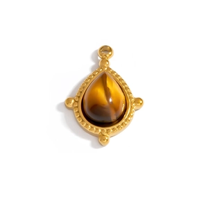Macro view of gold teardrop tiger eye pendant with vintage textured border details
