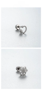 Detailed view of silver heart-shaped braided earrings and zircon-encrusted flower studs