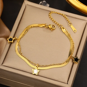 Detail of gold-plated stainless steel double-layered star bracelet on a jewelry box