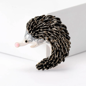 Detailed close-up of a hedgehog brooch with enamel finish on a clean white background