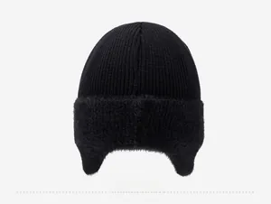 Vue arrière d'un bonnet d'hiver noir tricoté avec protection d'oreille en fausse fourrure