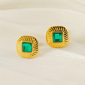 Vintage style gold titanium steel square earrings with green zircon on white silk fabric