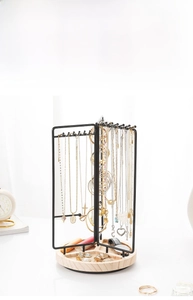 Detail view of rotating metal jewelry rack with wooden tray showing storage specifications