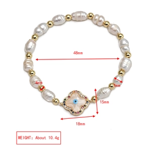 Detail view of the freshwater pearl bracelet with lucky blue devil eye clover charm