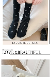 Detailed view of breathable black knit socks with delicate bow patterns for women