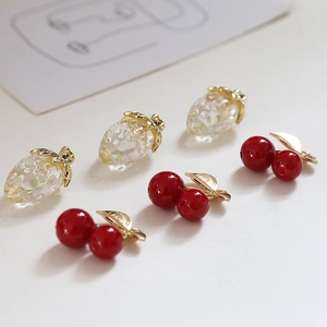 DIY jewelry pendants featuring translucent strawberries and red cherries with gold leaves