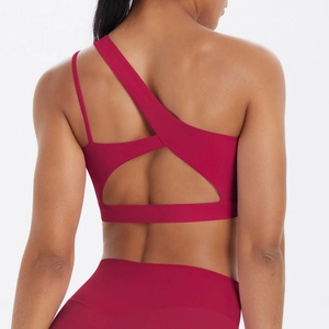 Close-up of asymmetric crisscross straps on a burgundy nylon sports bra with matte finish