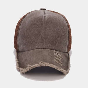 Dettaglio della visiera consumata del cappello trucker vintage in mesh taupe e marrone
