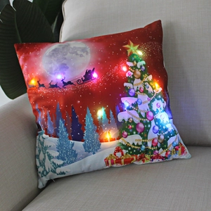 Detail of Christmas pillow with LED lights showing Santa's sleigh over a snowy red night