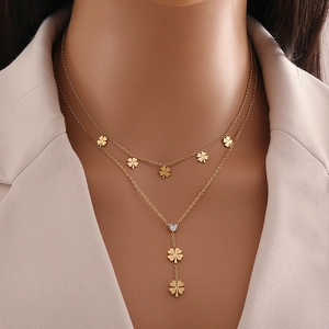 Double-layered gold necklace featuring clover charms and a heart-shaped zircon pendant