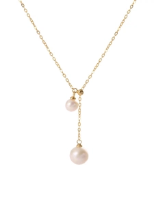 Detail of gold titanium necklace featuring dual white pearls in Y-shaped design