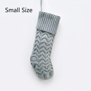 Detailed knit pattern on small greyish-blue Christmas stocking with hanging loop