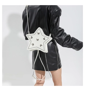 Detail of white star-shaped shoulder bag with metal studs and butterfly ornaments