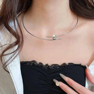 Detail of silver collar necklace with oval crystal stone and spiked design