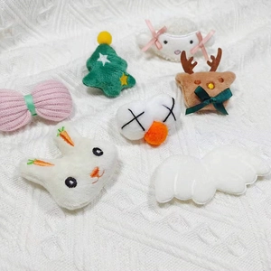 Détails de décorations en peluche (mouton, lapin, renne) sur un tissu en maille blanche