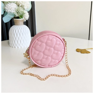 Detailed shot of pink heart-quilted round crossbody bag with gold chain and flower pendant