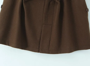 Vue détaillée d'une jupe en laine marron foncé avec boutons ronds décoratifs assortis